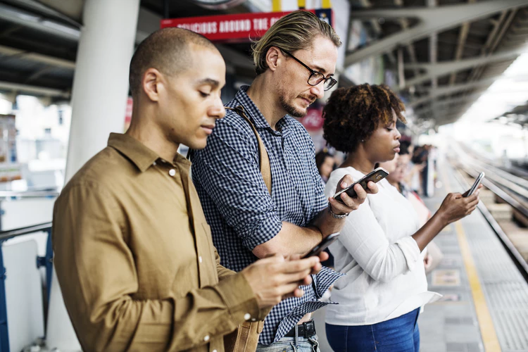 Pessoas mexendo no celular e realizando engajamento nas redes sociais.