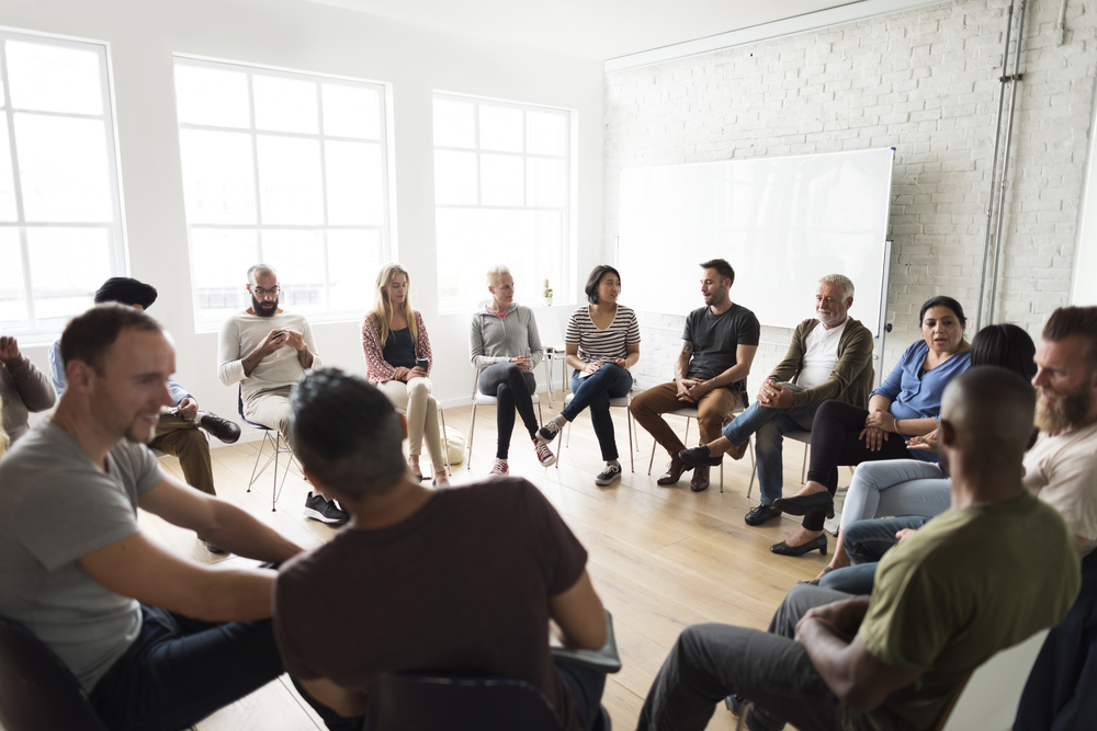 Pessoas reunidas em círculo para dinâmica de motivação.