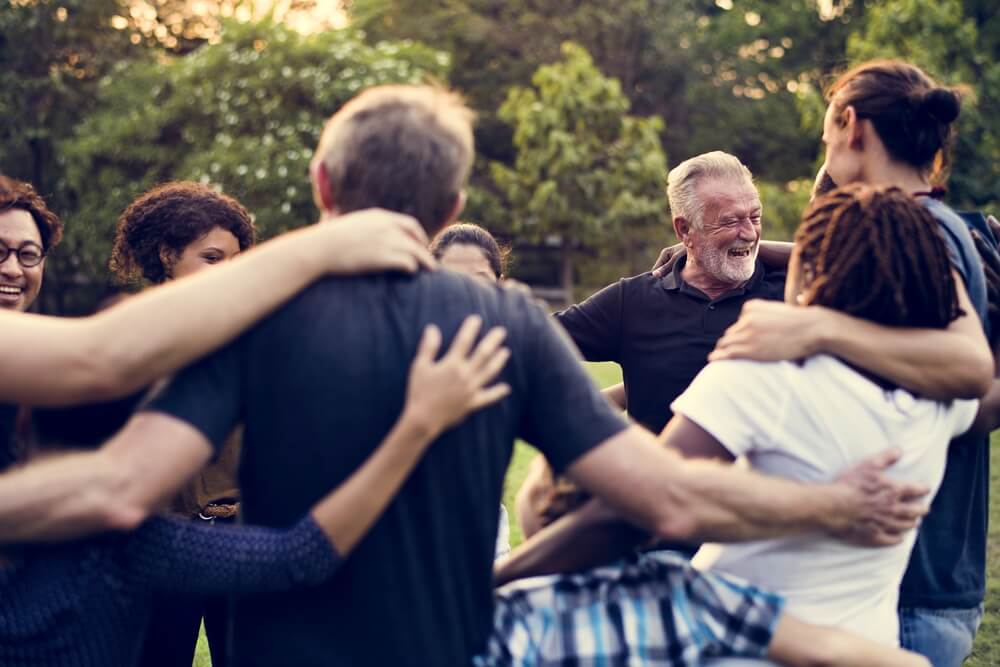 Pessoas de várias idades se abraçando.