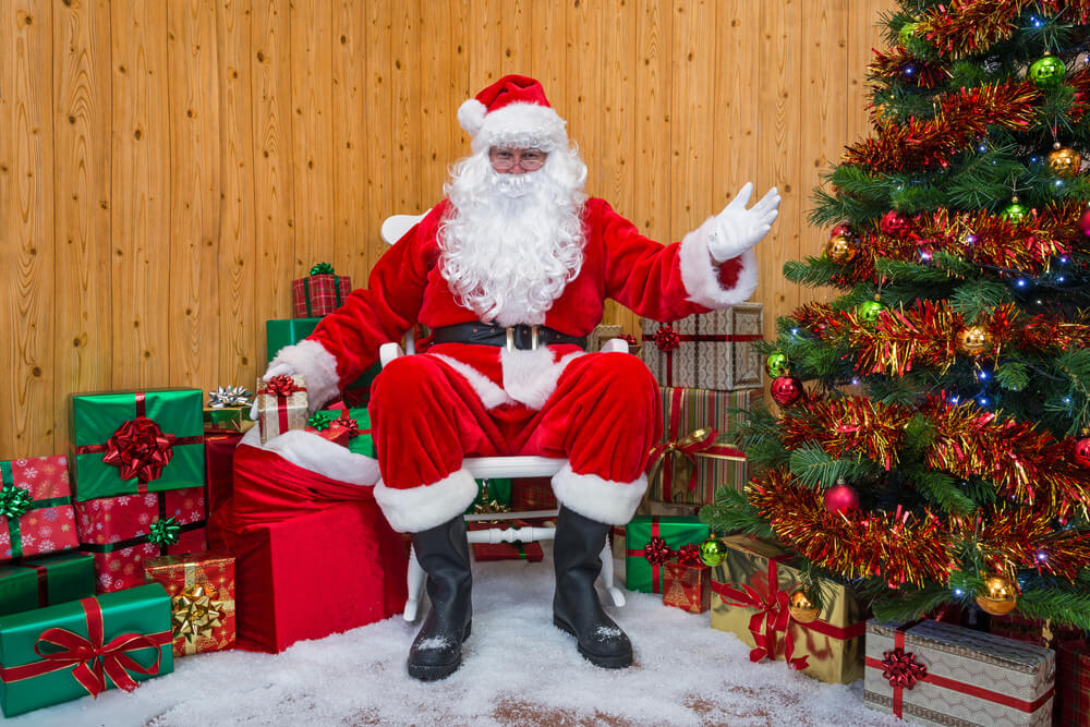 Papai Noel sentado na loja de calçados durante promoção de fim de ano natalino.