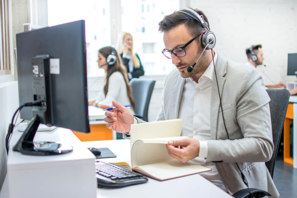 Vendedor realizando o estudo do cliente inadimplente antes de realizar a cobrança.